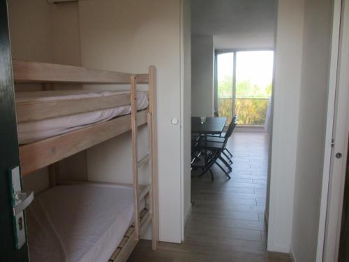 une chambre avec des lits superposés et une salle à manger avec une table dans l'établissement Appartement En Bord De Mer Avec Piscine, à Saint-Cyprien