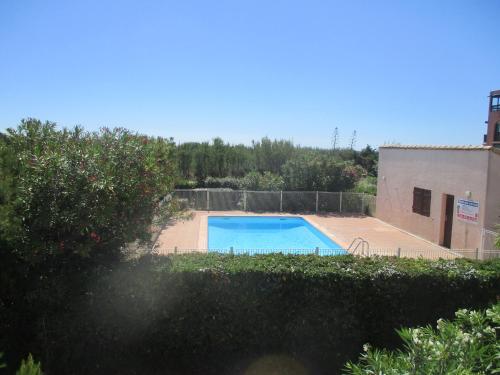 una piscina in un cortile con una recinzione di Appartement En Bord De Mer avec piscine a Saint-Cyprien