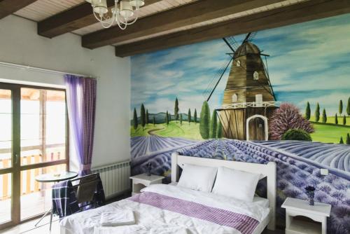 スラブスクにあるPogar Innの風車の壁画が施されたベッドルーム