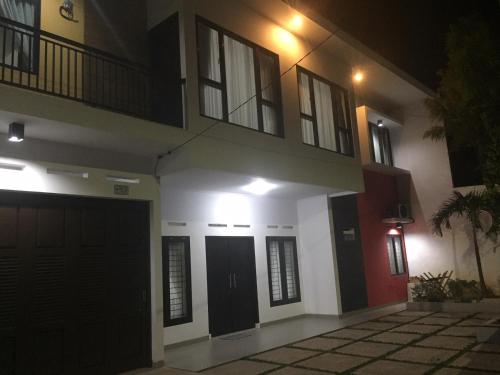 a house at night with the front doors illuminated at Rumah99 in Jakarta