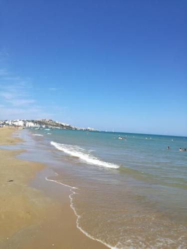 a beach with people swimming in the ocean at Laura in Vieste