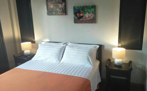a bedroom with a bed with two lamps on tables at Sean Sabai Home e Ristobar in Taling Ngam Beach