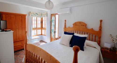 a bedroom with a wooden bed with blue and white pillows at Beach Holiday Home Fue in Gran Tarajal