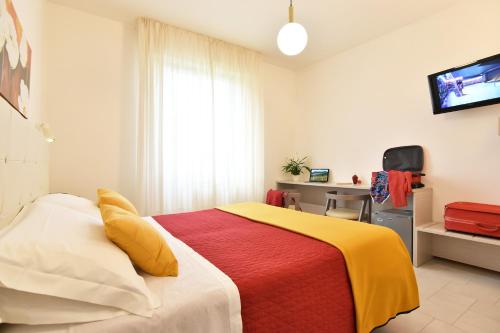 a bedroom with a bed with a yellow and red blanket at Hotel Del Buono Wellness & Medical Spa in Chianciano Terme