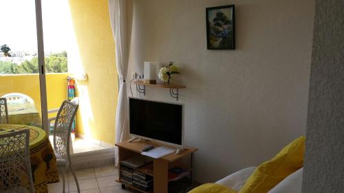 a living room with a television on a table at WIFI Appartement Panoramisch Zeezicht max 4 personen in Narbonne Plage in Narbonne-Plage