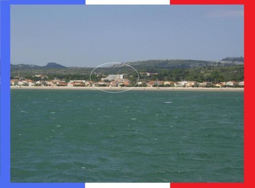 a kite flying over the ocean with a beach in the background at WIFI Appartement Panoramisch Zeezicht max 4 personen in Narbonne Plage in Narbonne-Plage