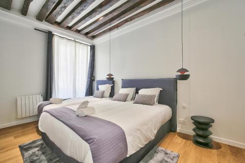 パリにある69 - Authentic Parisian Homeのベッドルーム(紫の毛布を使用した大型ベッド1台付)