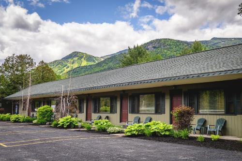 a building with chairs and mountains in the background at Hungry Trout Resort in Wilmington