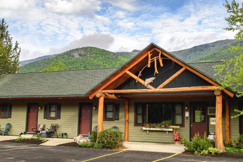a house with a gambrel roof with mountains in the background at Hungry Trout Resort in Wilmington