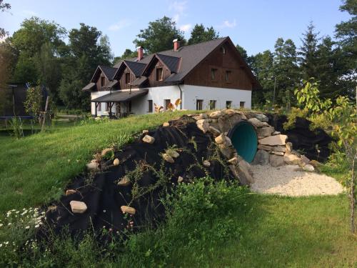 a house with a stone wall in front of a building at Penzion Terezka in Králíky