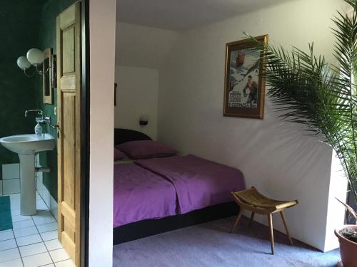 sypialnia z fioletowym łóżkiem i umywalką w obiekcie Penzion Prezident w mieście Soběraz