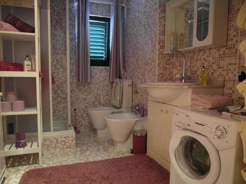 y baño con lavamanos y lavadora. en Creska IV en Rijeka