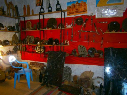 a room with a red wall with lots of antiques at Gite Tamlli in Aoufous
