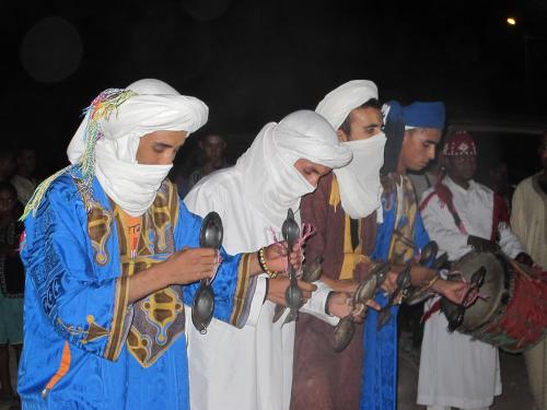 a group of people standing together holding utensils at Gite Tamlli in Aoufous