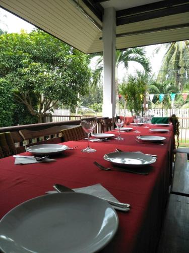 a long table with red table cloth and wine glasses at Sean Sabai Home e Ristobar in Taling Ngam Beach