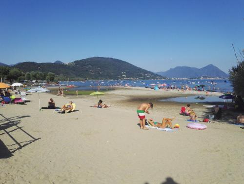 a group of people on the beach at the beach at Danilo Apartments in Baveno
