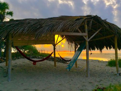 a straw hut with a hammock on a beach at Beach Hut by S.A.R. in Waingapu