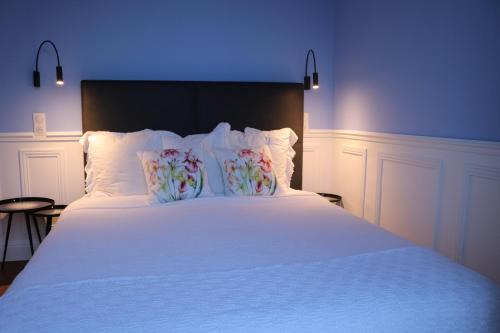 a bed with white sheets and pillows with a blue light at Tres Bel Appartement Vieux Port De Bastia in Bastia