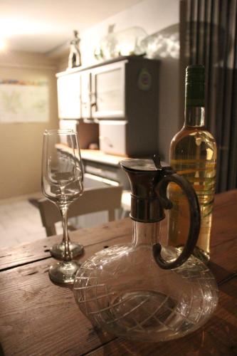 een fles wijn en een wijnglas op een tafel bij MUSTACH House in Saint-Maurice-sous-les-Côtes