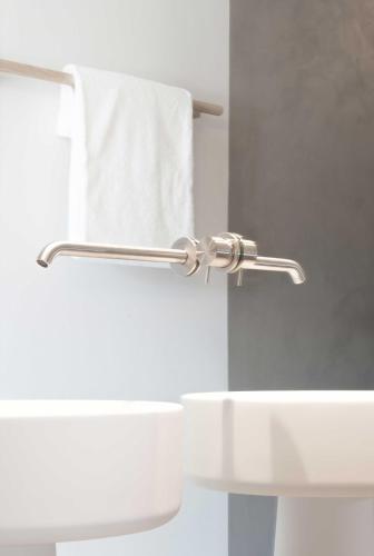 a white bathroom with a towel rack and a sink at Schgaguler Hotel in Castelrotto