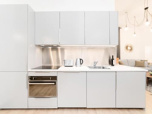 - une cuisine blanche avec des placards blancs dans l'établissement LivinParis - Luxury 3 & 4 Bedrooms Montmartre I, à Paris