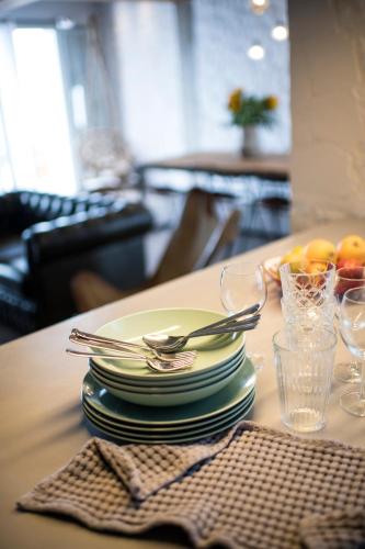 a table with a stack of plates and glasses on it at Villa Vivere in Asos