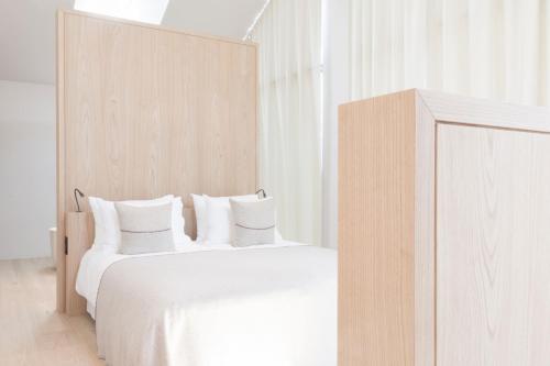 a bedroom with two beds with white sheets and pillows at Schgaguler Hotel in Castelrotto