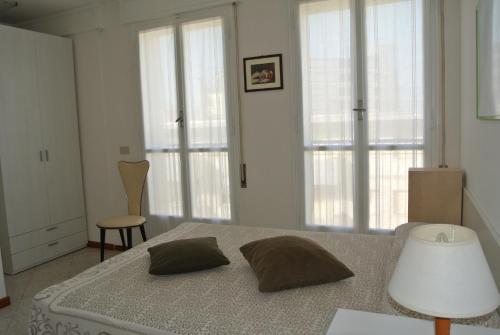 a bedroom with a bed with two pillows on it at Appartamento CRISTALLO 25 in Lignano Sabbiadoro