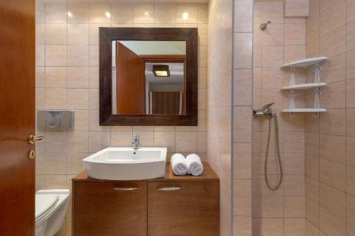 a bathroom with a sink and a shower with a mirror at Villa Lahania in Lachania