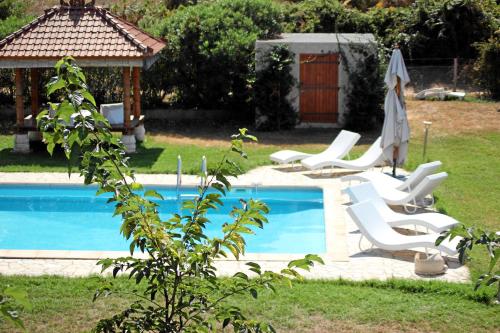 a swimming pool with white chairs and a gazebo at Monica di Sorbo in Sorbo-Ocagnano