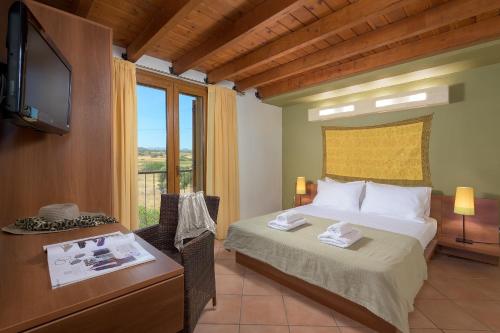 a bedroom with a bed and a desk and a television at Villa Lahania in Lachania
