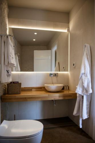 a bathroom with a sink and a toilet and a mirror at Villa Vivere in Asos