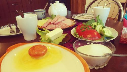 a table with plates of food on a table at Noclegi U Dyncyka in Krajno Pierwsze