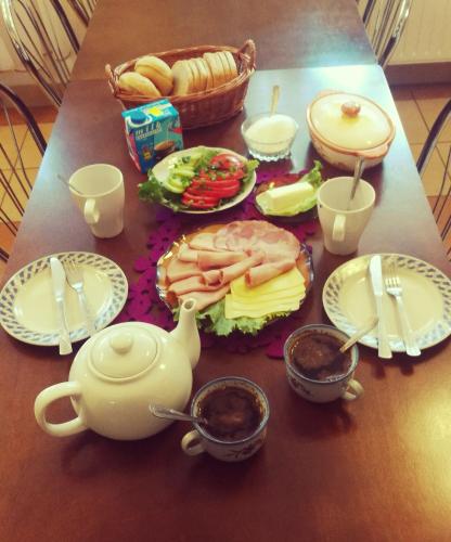 a table with plates of food and a teapot at Noclegi U Dyncyka in Krajno Pierwsze