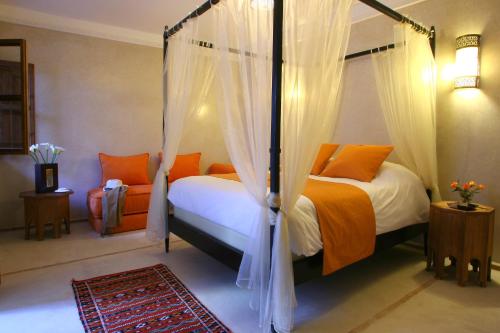 - une chambre avec deux lits et un lit à baldaquin dans l'établissement Riad CHERRATA, à Marrakech