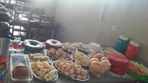 uma mesa coberta com pratos de diferentes tipos de alimentos em Pousada Jesus De Nazare em Trindade
