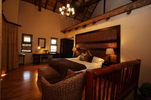 a bedroom with a large bed and a chair at Oak Park and Conference Centre in Kokstad