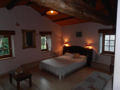 une chambre avec un lit et deux fenêtres dans l'établissement la Platière, à Yves