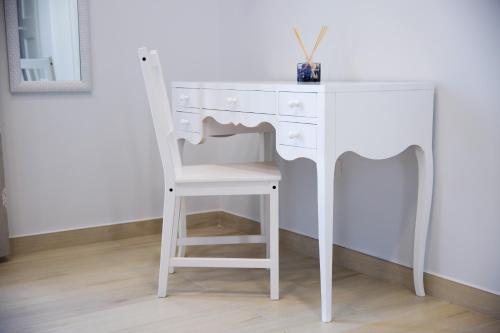 a white desk with a chair next to a table at Gleda Rooms Deluxe in Pompei