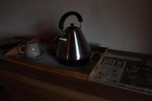 a tea kettle and a cup on a wooden tray at Maison Chenal in Montjovet