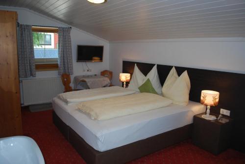 a bedroom with a large bed with two lamps at Haus Deutinger in Piesendorf