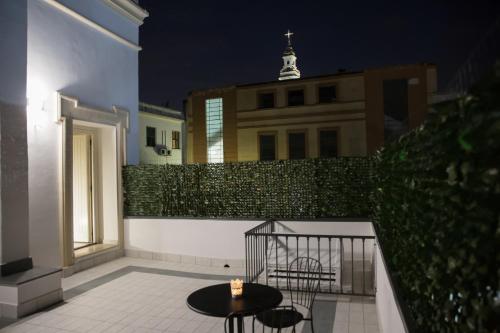 a patio with a table and chairs and a fence at Gleda Rooms Deluxe in Pompei