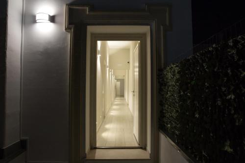 a hallway with a mirror on a wall at Gleda Rooms Deluxe in Pompei