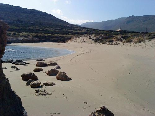 a beach with rocks in the sand and water at Beachfront Apartment Kato Zakros in Káto Zákros