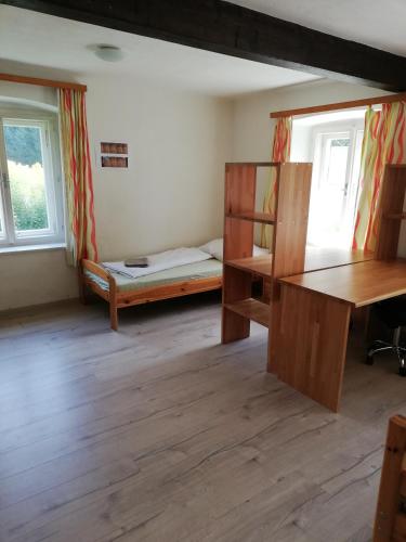 a room with a bed and a desk and windows at Amtmannhaus Ferienunterkunft in Irdning