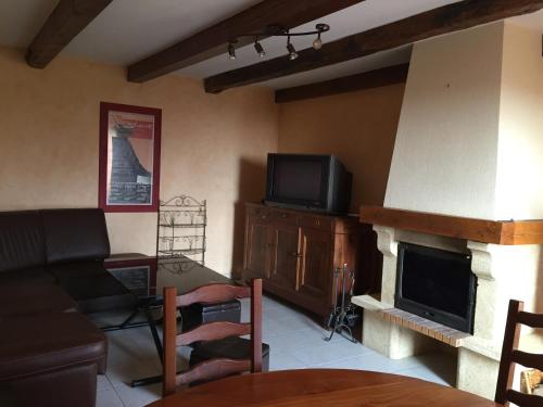 ein Wohnzimmer mit einem Sofa und einem Kamin in der Unterkunft La Maison de Gaston in Saint-Cirgue