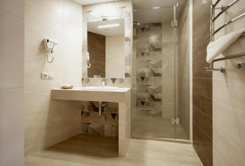 ein Bad mit einem Waschbecken und einer Dusche in der Unterkunft Hotel Natalia 18 in Lwiw