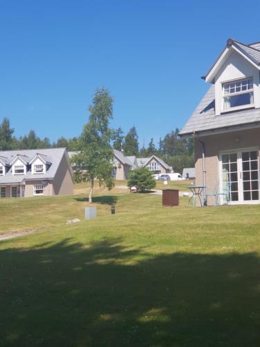 a house with a large yard with a tree at Inchmarlo villa27 in Banchory