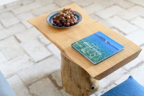 a book sitting on a table with a plate of grapes at Elia Residences Santorini in Karterados