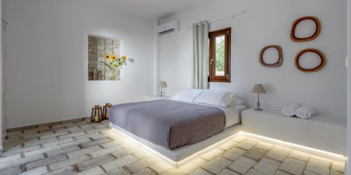 una camera bianca con un letto e una finestra di Elia Residences Santorini a Karterados